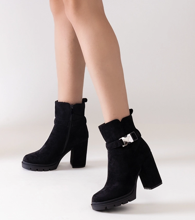 Cerné boty na sloupku zdobené přezkou Torhia.